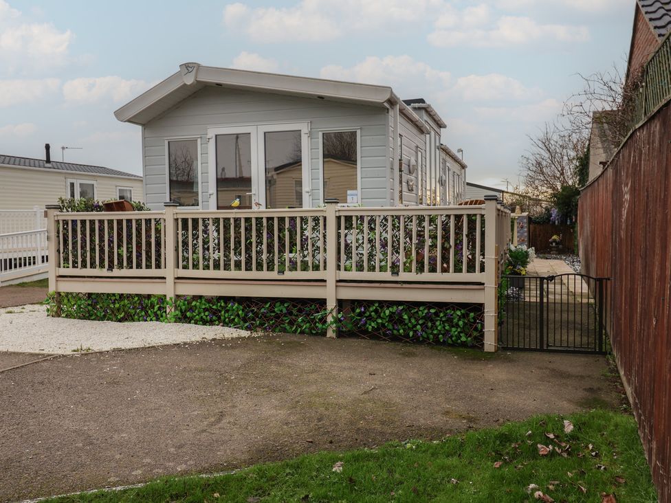 A house with a deck and gate at Offspray Court 1 Scratby