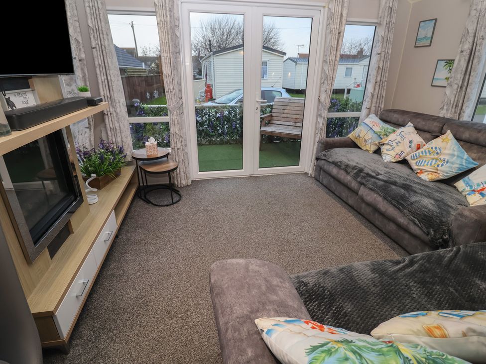 A living room with a sofa and coffee table at Offspray Court 1 Scratby