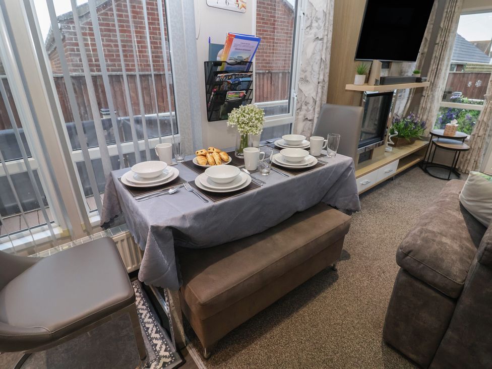 A dining area with a set table at Offspray Court 1 in Scratby