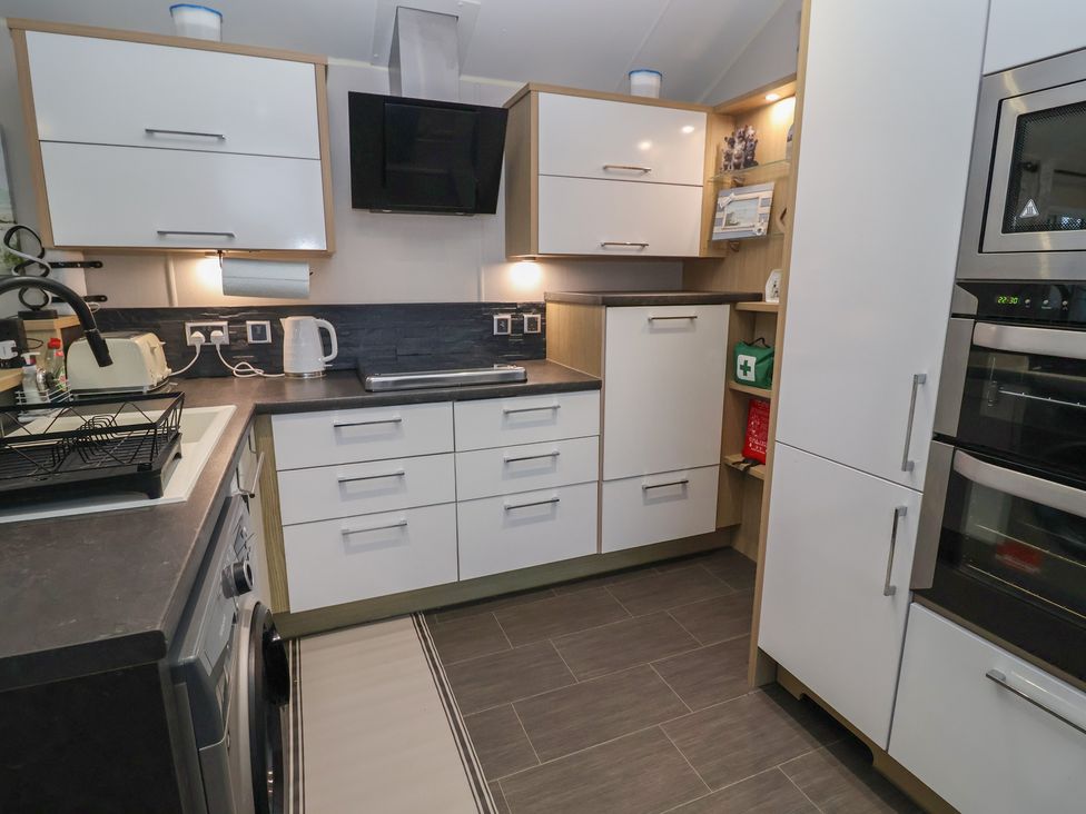 A kitchen with cabinets and appliances at Offspray Court 1 Scratby