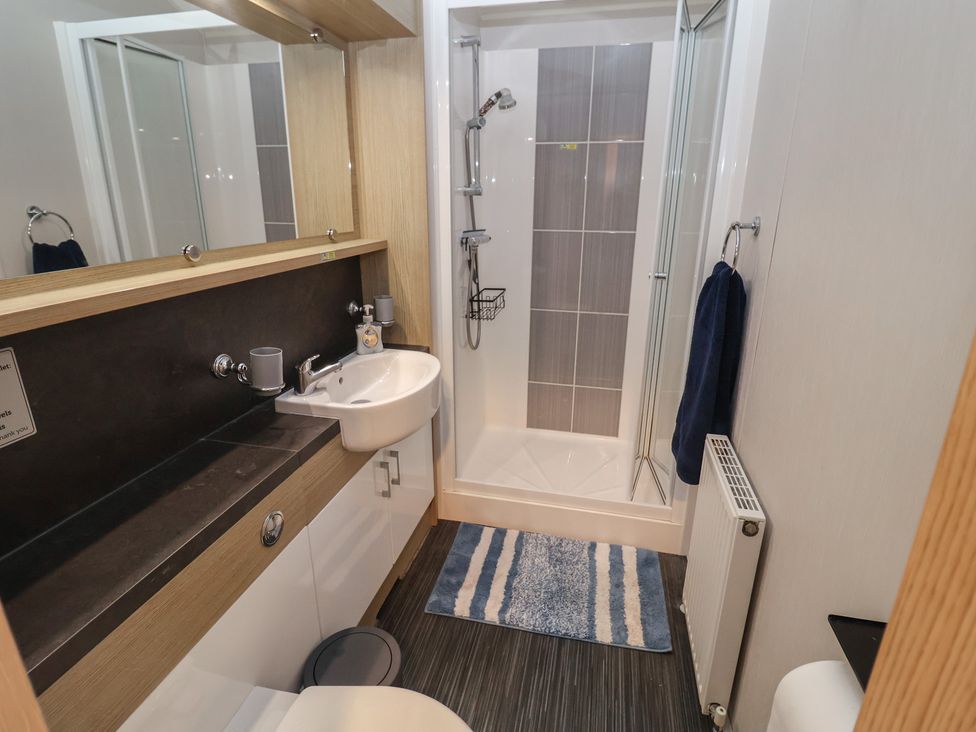 A bathroom with a sink and shower at Offspray Court 1 in Scratby