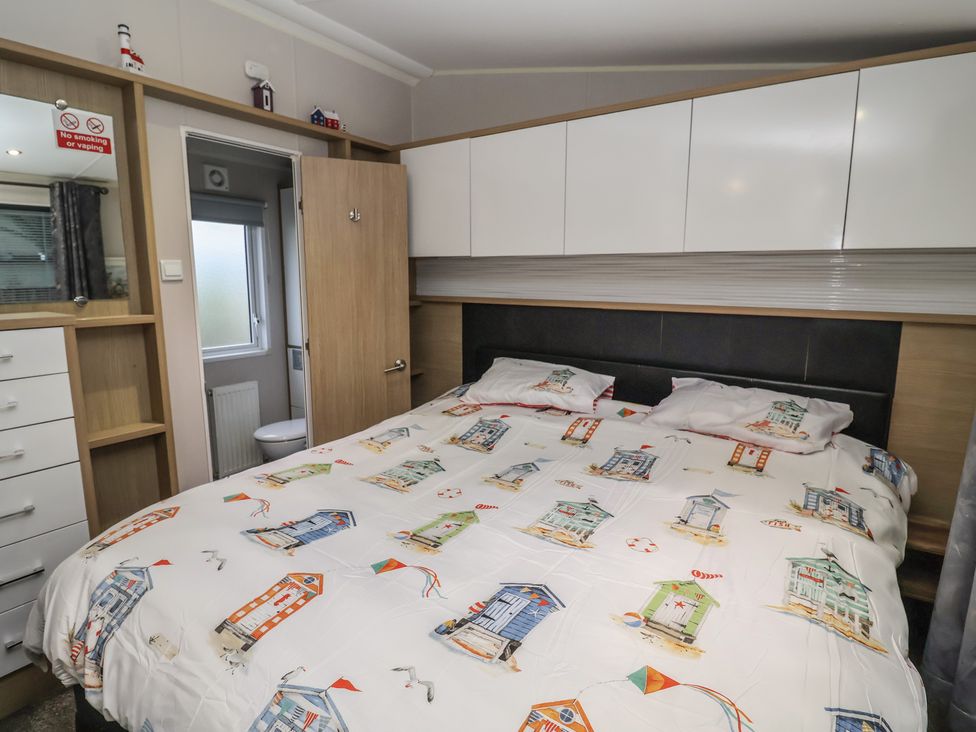 A bedroom with a bed and a wardrobe at Offspray Court 1 Scratby