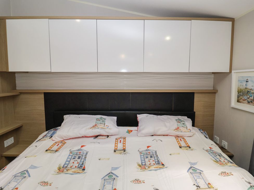 A bedroom with a bed and wardrobe at Offspray Court 1 Scratby