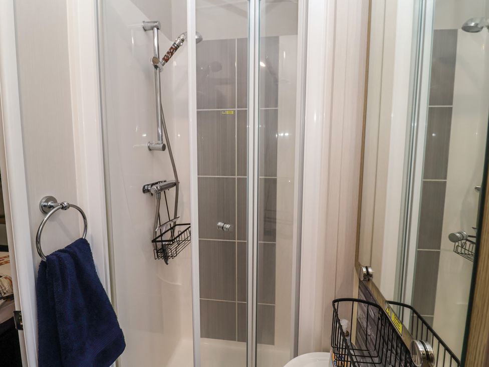 A shower with towel rack and basket at Offspray Court 1 Scratby