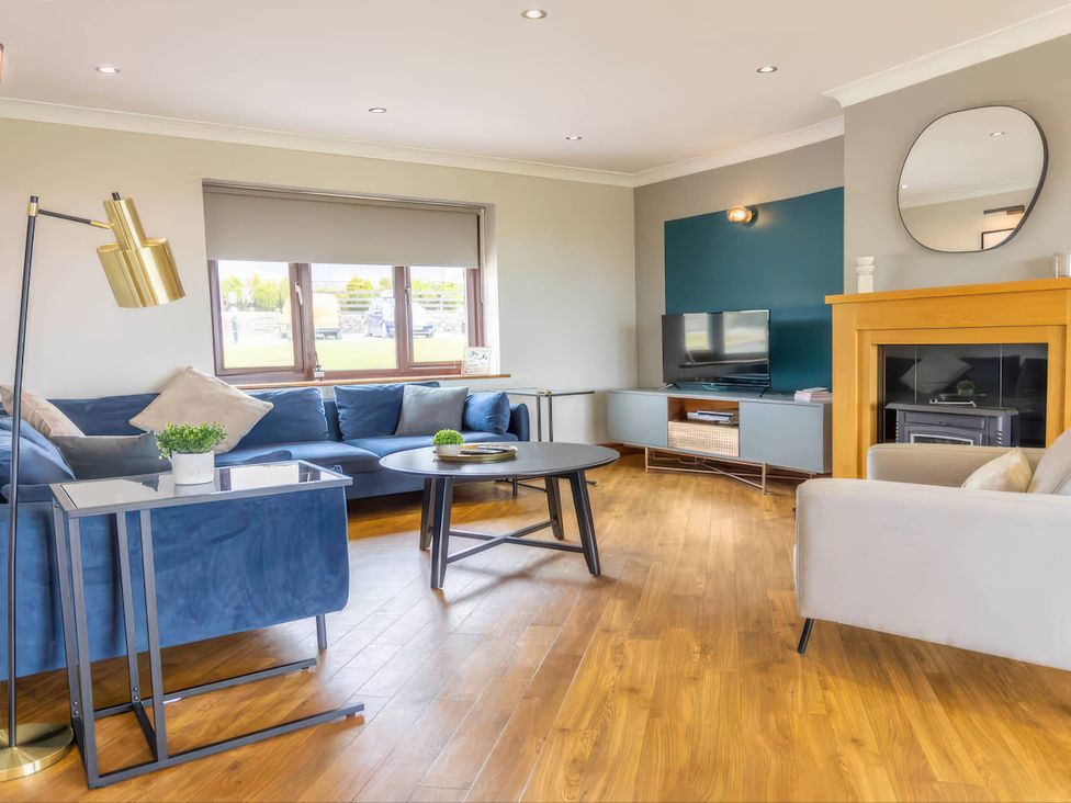 A living room with a sofa and coffee table at Kestrel Cottage in Llangaffo