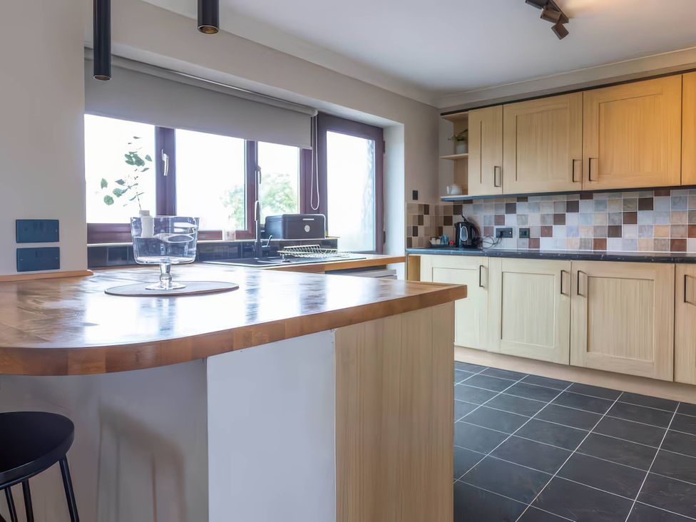 A kitchen with cabinets and a countertop at Kestrel Cottage Llangaffo