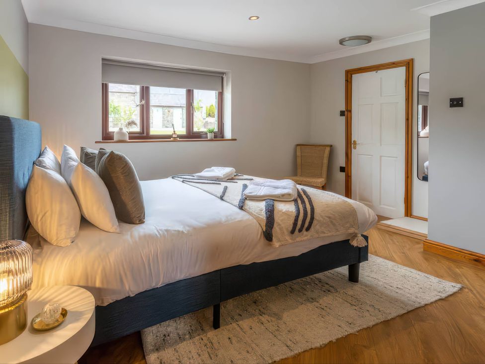 A bedroom with a bed and a bedside table at Kestrel Cottage in Llangaffo