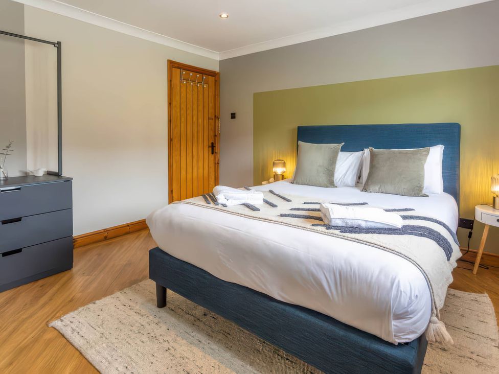 A bedroom with a bed and furniture at Kestrel Cottage Llangaffo