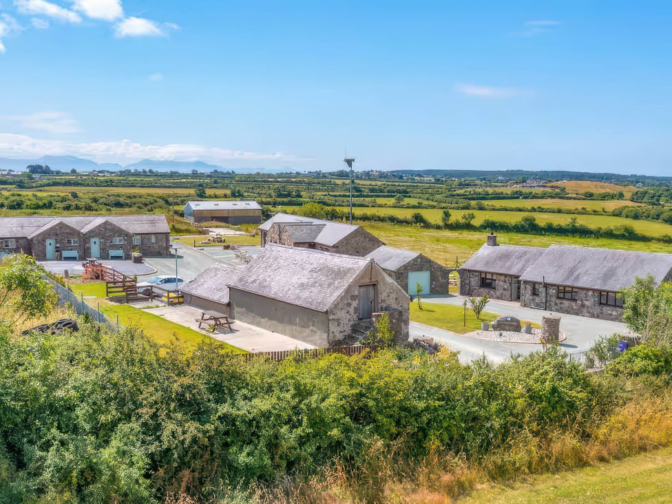 An outdoor view of buildings and garden at Swan Cottage in Llangaffo