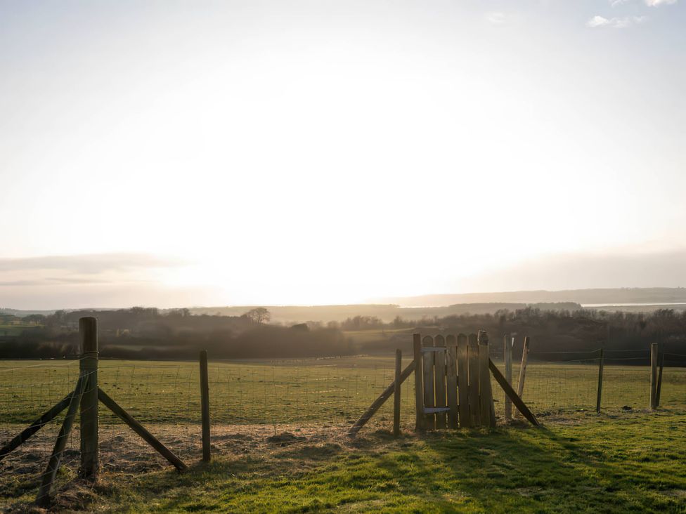 A fence and gate in a field at Swan Cottage in Llangaffo