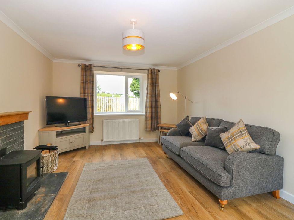 A living room with a sofa and television at Bankhead Of Lour Cottage Forfar