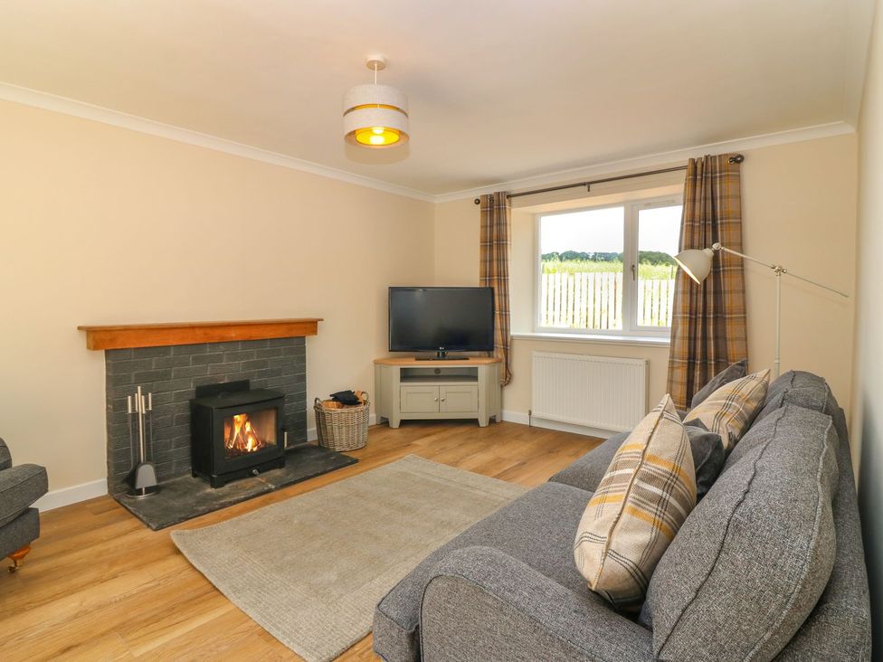 A living room with a fireplace and sofa at Bankhead Of Lour Cottage Forfar