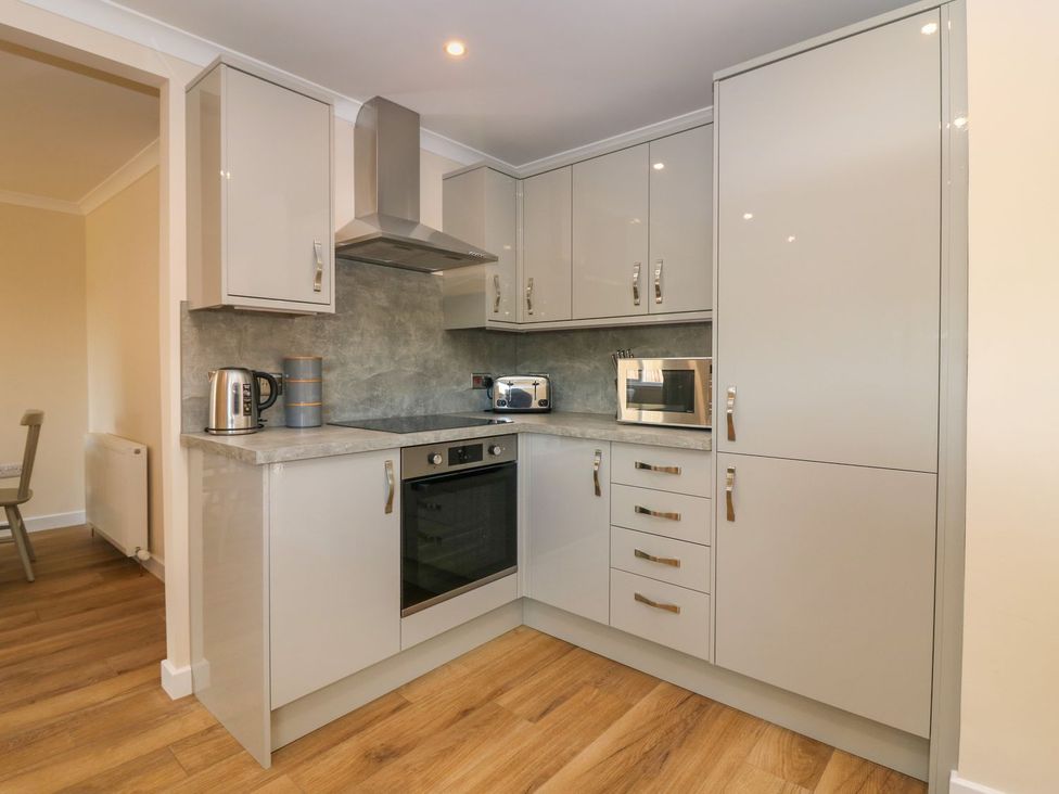 A kitchen with cabinets, kettle, toaster and microwave at Bankhead Of Lour Cottage in Forfar