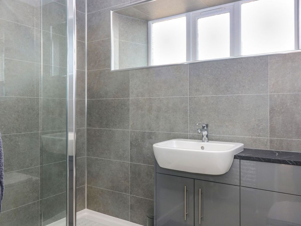 A bathroom with a shower and sink at Bankhead Of Lour Cottage Forfar