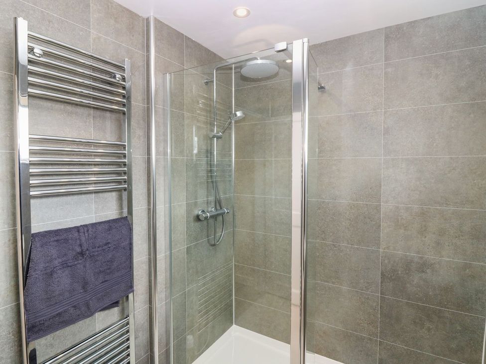 A bathroom with a shower enclosure and towel rail at Bankhead Of Lour Cottage Forfar