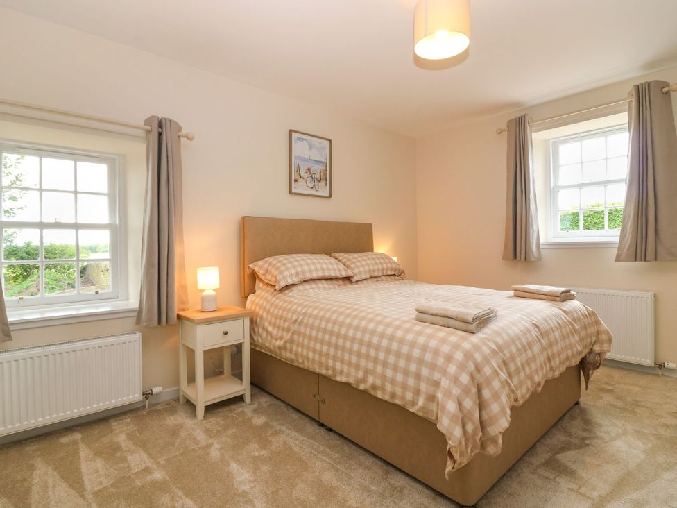 A bedroom with a bed and bedside table at Bankhead Of Lour Cottage Forfar