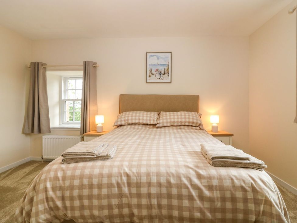 A bedroom with a double bed and bedside lamp at Bankhead Of Lour Cottage in Forfar