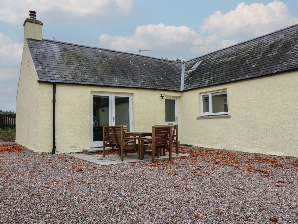 An outdoor patio with a table and chairs at Bankhead Of Lour Cottage in Forfar