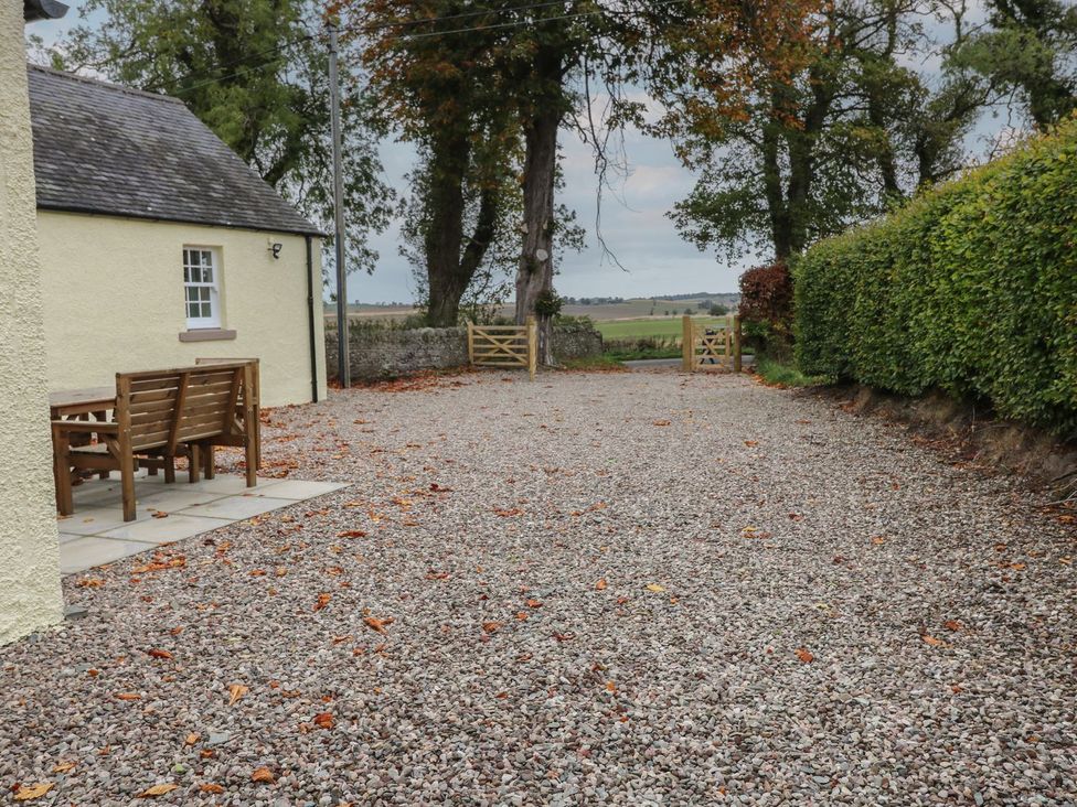 A gravel area with a bench next to a gate at Bankhead Of Lour Cottage Forfar