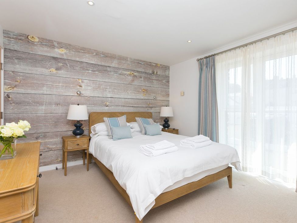 A bedroom with a double bed and a wooden wall at Mid Air in St. Ives