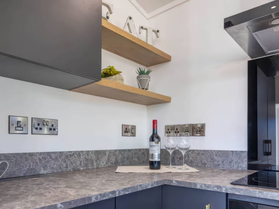 A kitchen with a wine bottle and glasses on the counter at Isca Lodge - With Decking - Lodge 1 Wombleton
