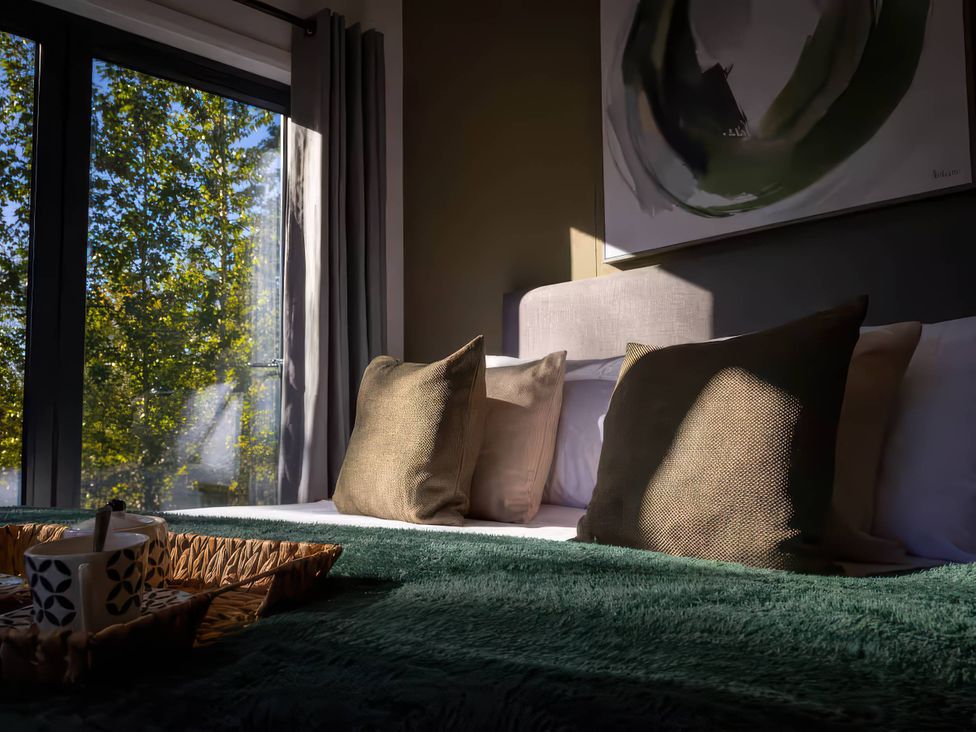 A bedroom with a bed and pillows at Isca Lodge - With Decking - Lodge 1 in Wombleton