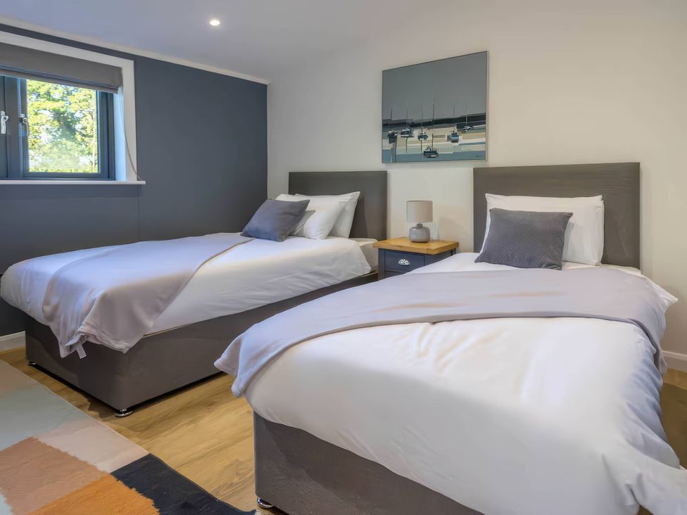 A bedroom with two beds and a nightstand at Isca Lodge - With Decking - Lodge 1 Wombleton
