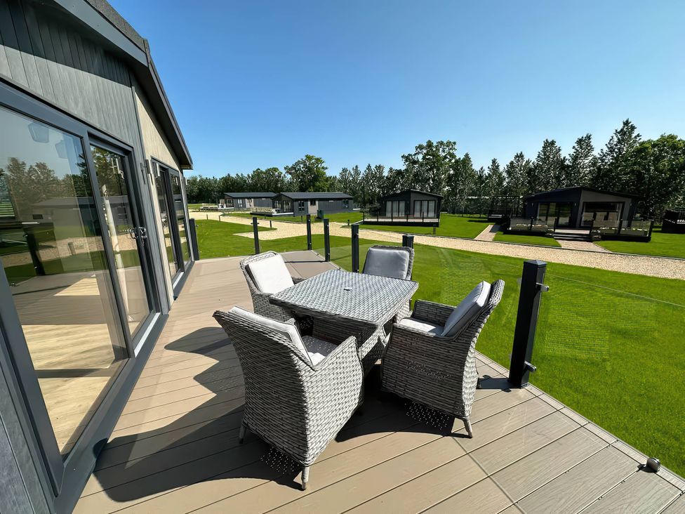An outdoor seating area with a table and chairs at Isca Lodge - With Decking - Lodge 1, Wombleton
