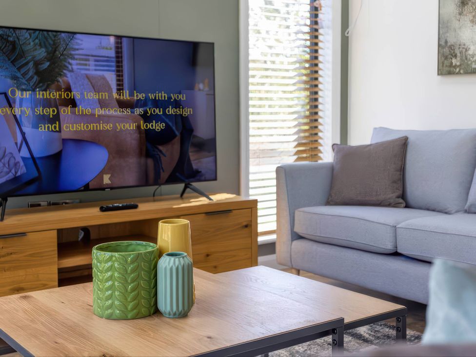 A living room with a television and decorative vases at Isca Lodge Wombleton