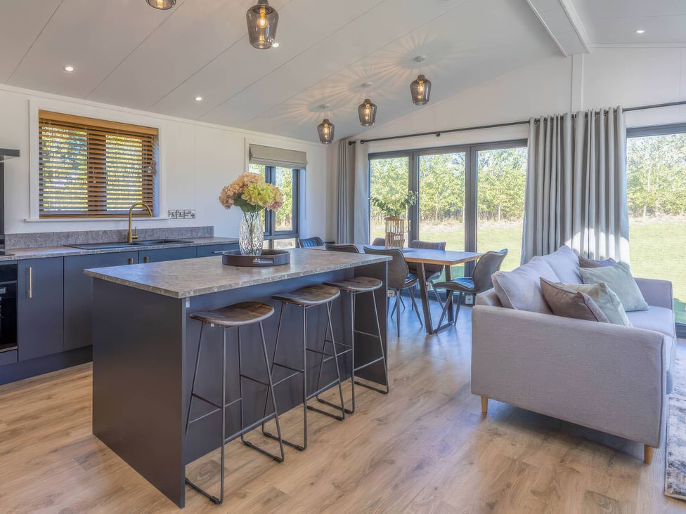 A kitchen with an island and dining area at Isca Lodge in Wombleton