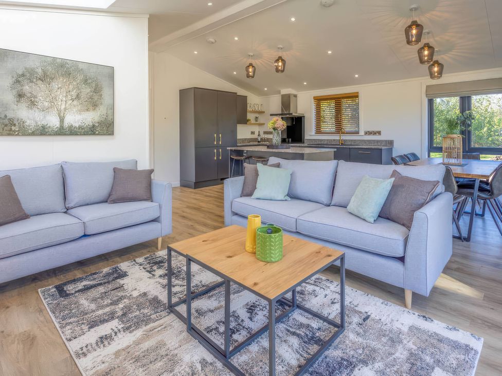 A living room with a sofa and table at Isca Lodge in Wombleton