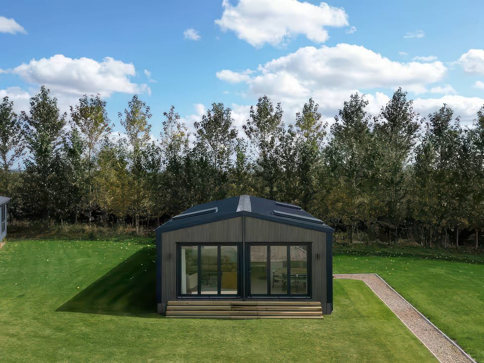 A house with large windows and a pathway at Rye Lodge in Wombleton