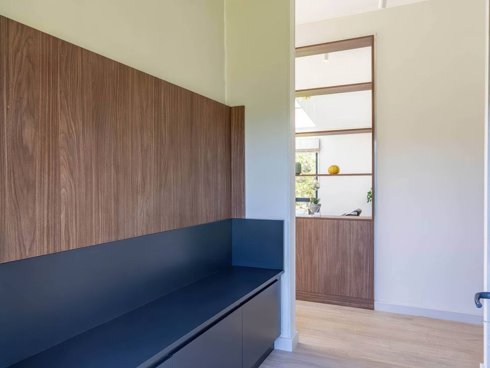 An entryway with a bench and shelves at Rye Lodge in Wombleton