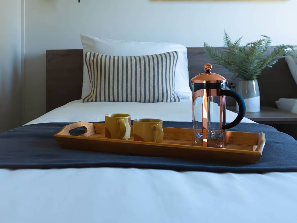 A bedroom with a bed and tray of coffee at Rye Lodge in Wombleton