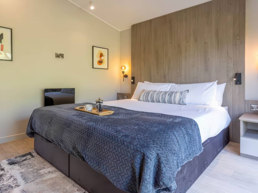 A bedroom with a bed and nightstand at Rye Lodge in Wombleton