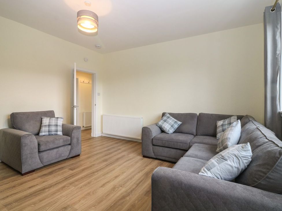 A living room with a sofa and armchair at Bankhead Of Lour Bungalow
