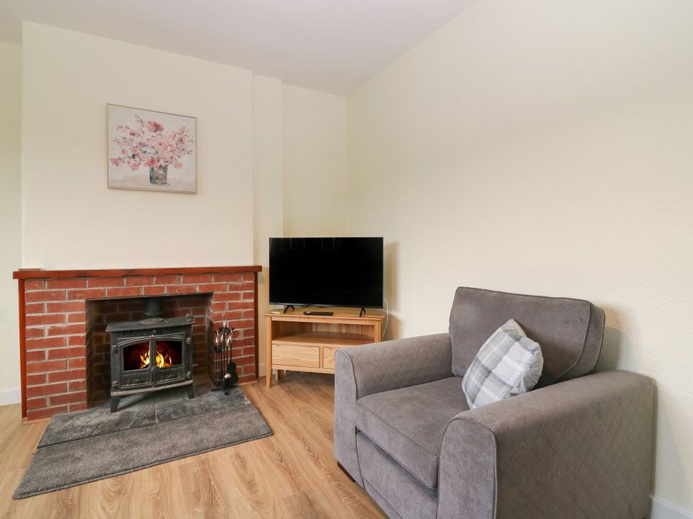 A living room with a fireplace and television at Bankhead Of Lour Bungalow