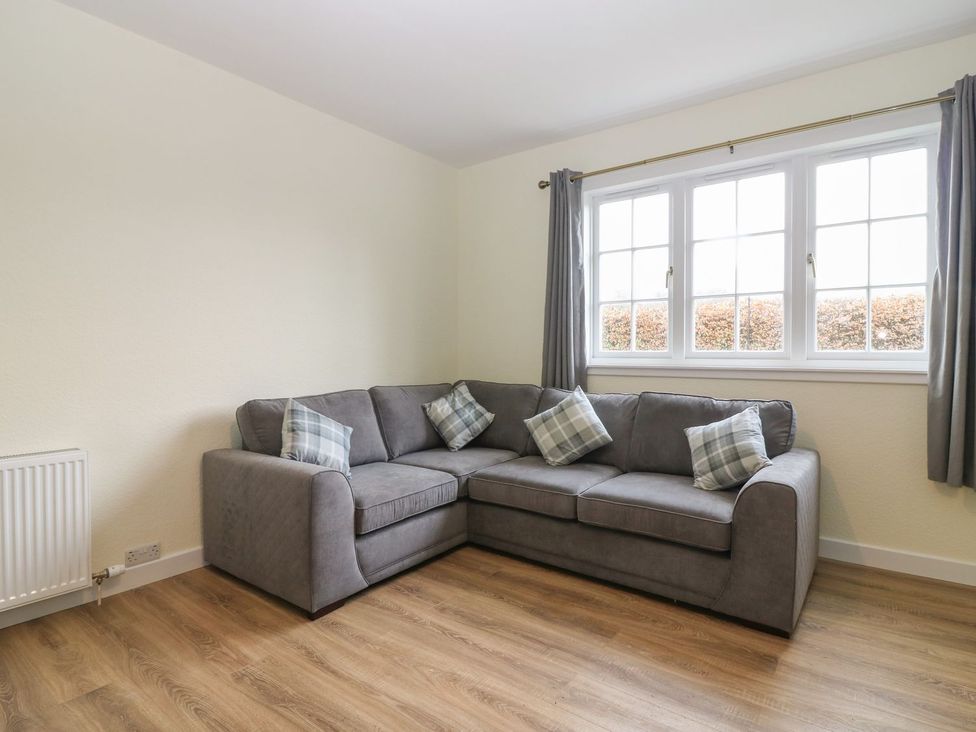 A living room with a sectional sofa and decorative pillows at Bankhead Of Lour Bungalow
