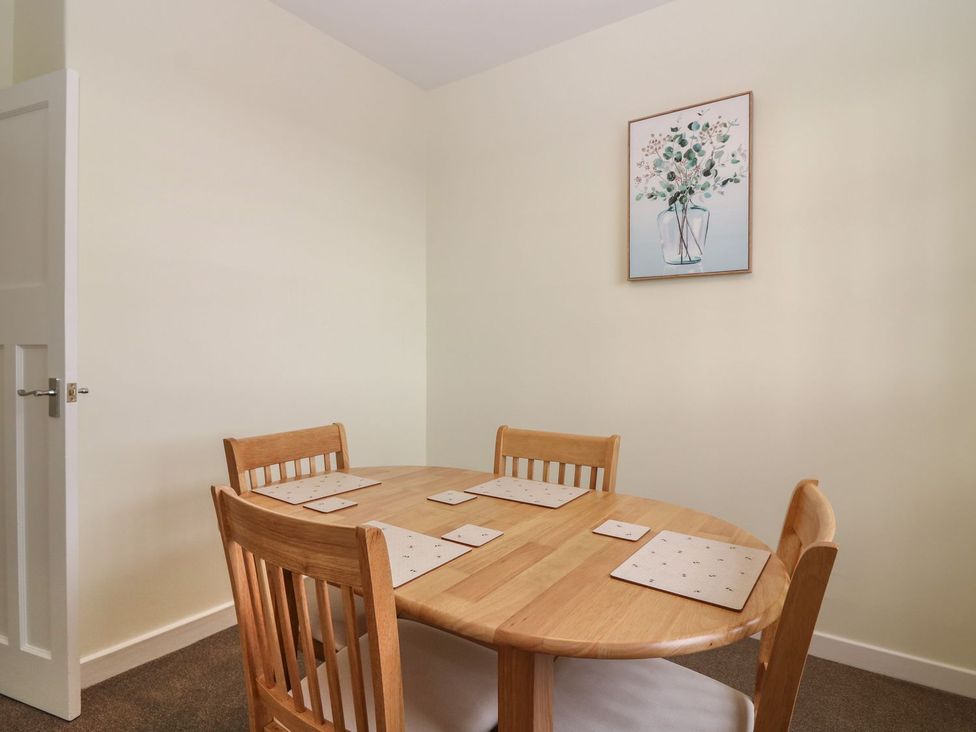 A dining room with a round table and chairs at Bankhead Of Lour Bungalow