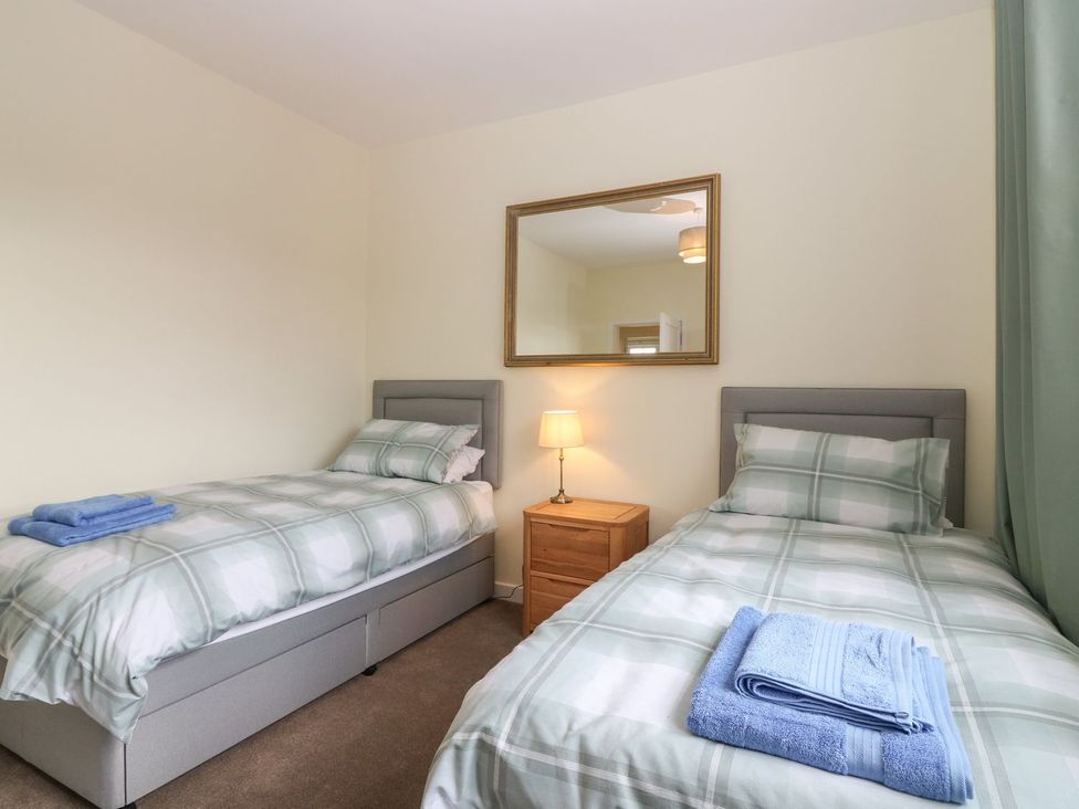 A bedroom with two beds and a lamp at Bankhead Of Lour Bungalow