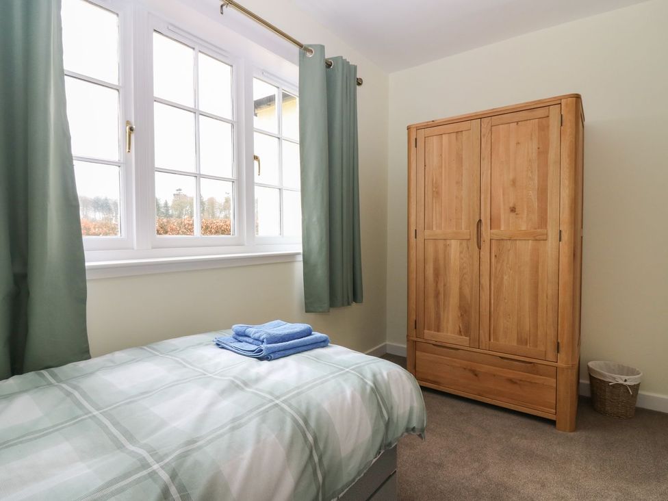 A bedroom with a bed and wardrobe at Bankhead Of Lour Bungalow