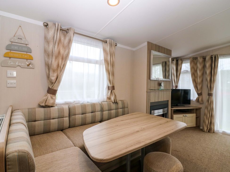 A living room with a sofa and table in Caravan number 77