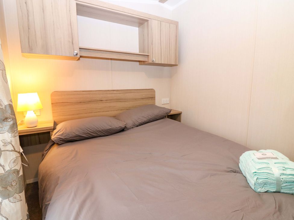 A bedroom with a bed and lamp at Caravan number 77