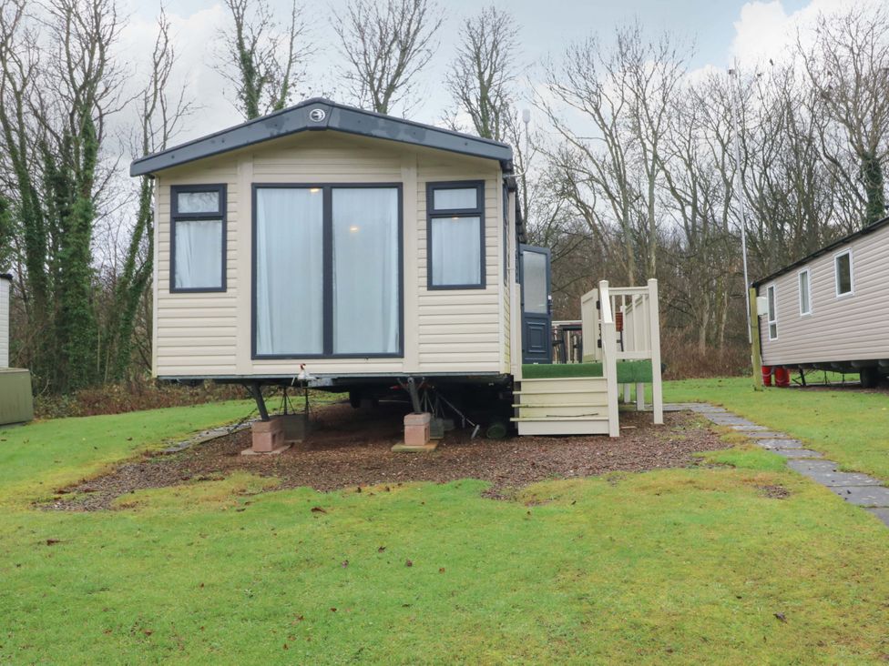 A caravan with steps and grass at Caravan number 77