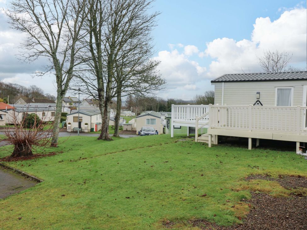 An outdoor scene with caravans and trees at Caravan number 77
