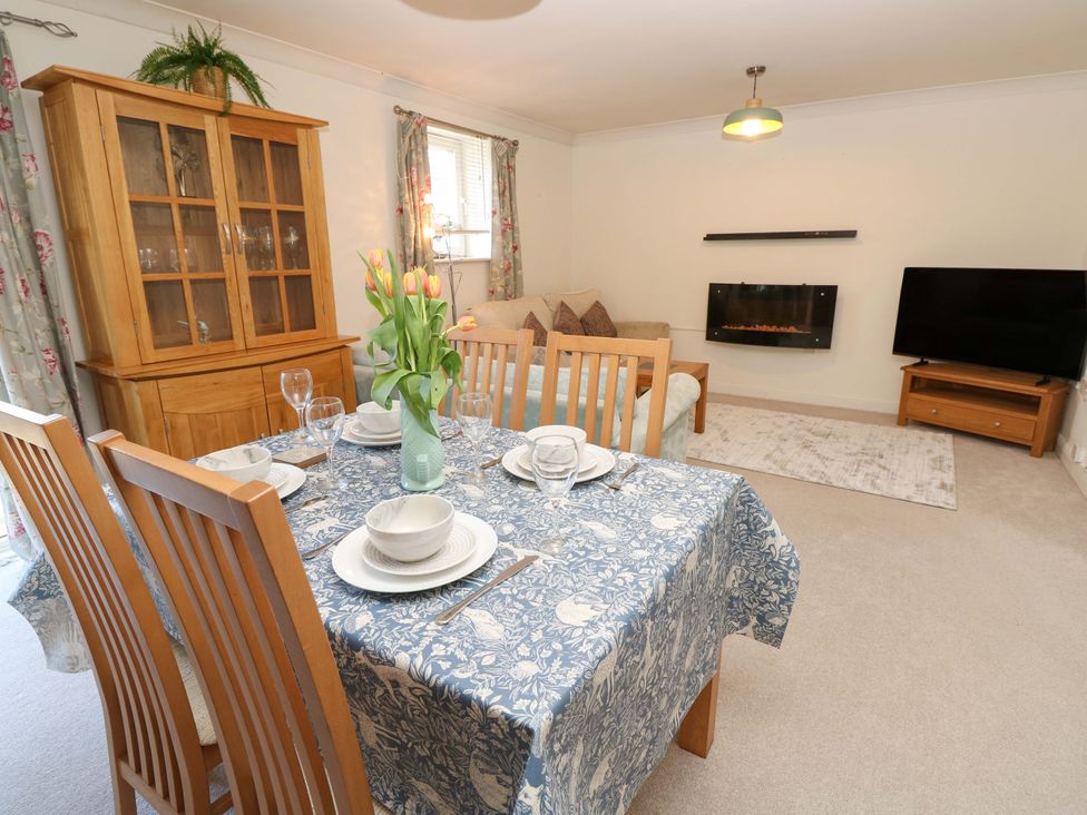 A dining area with a table set and a sofa in a living room at 53 Orchard Place