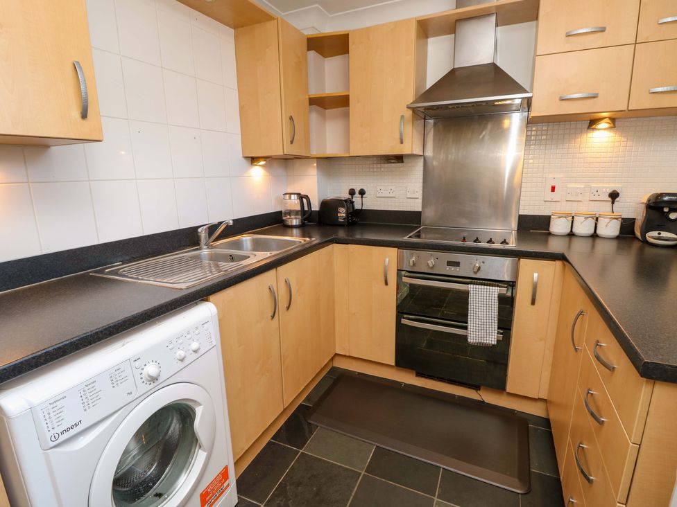 A kitchen with cabinets, sink, oven, and washing machine at 53 Orchard Place