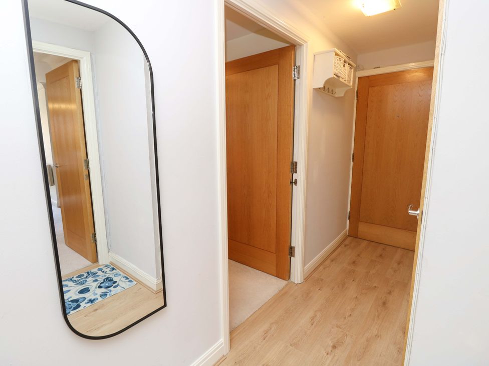 A hallway with a mirror and wooden doors at 53 Orchard Place