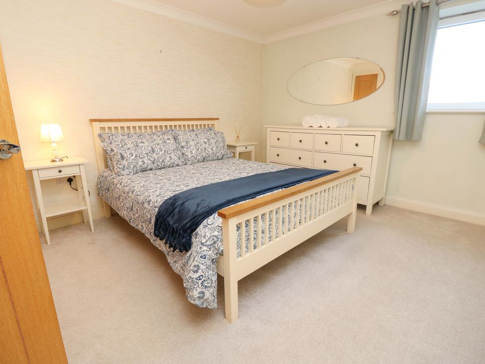 A bedroom with a bed, nightstand and dresser at 53 Orchard Place