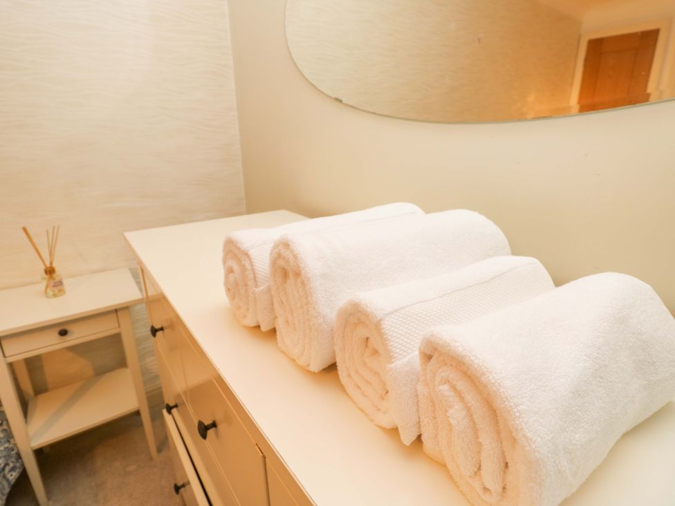 A bathroom with rolled towels on a dressing table at 53 Orchard Place